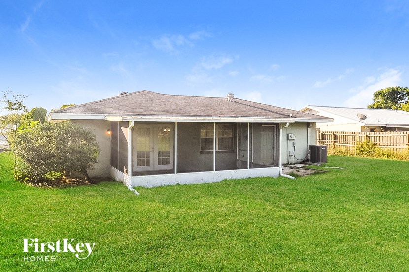 the backyard of a house with a lawn and a fence