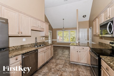 A kitchen with granite countertops and a tile floor.