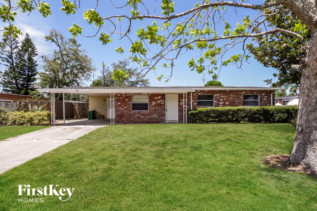 A house with a lawn and trees in the background.