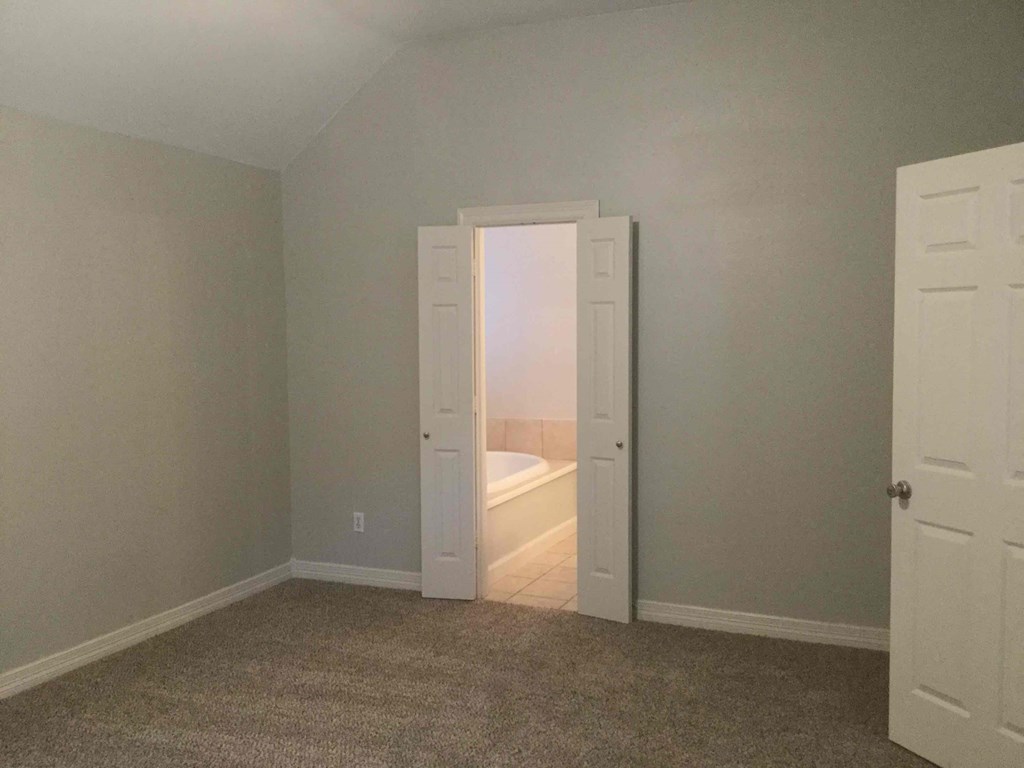 a room with a closet and a door to a bathroom