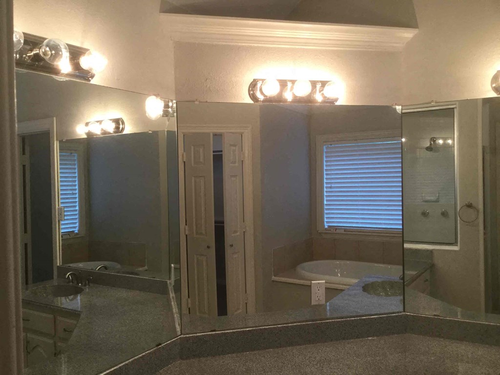 a bathroom with a large mirror and a tub and a sink