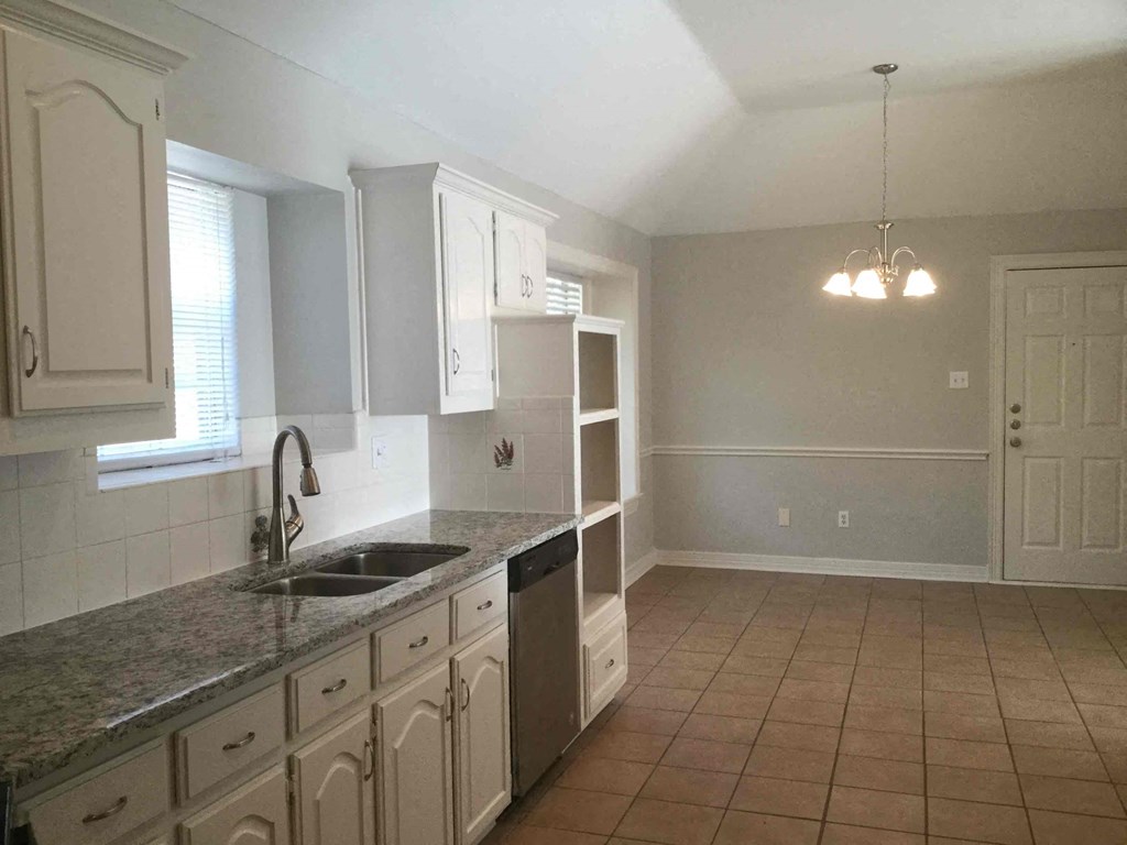 a kitchen with white cabinets and a sink