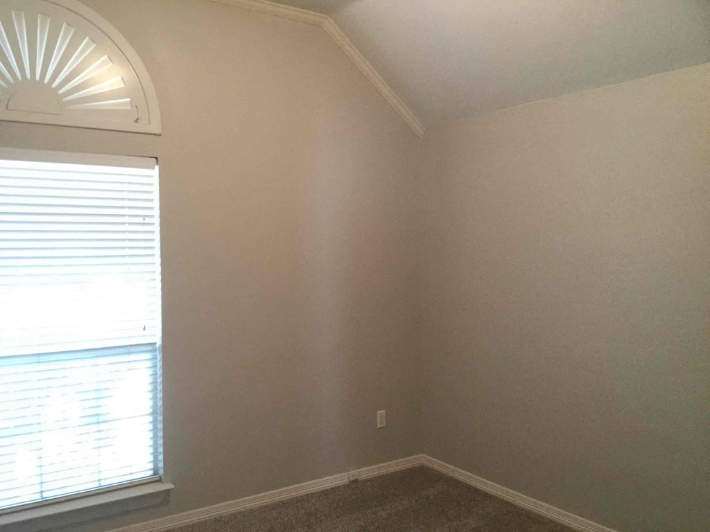 a room with a window and a carpet