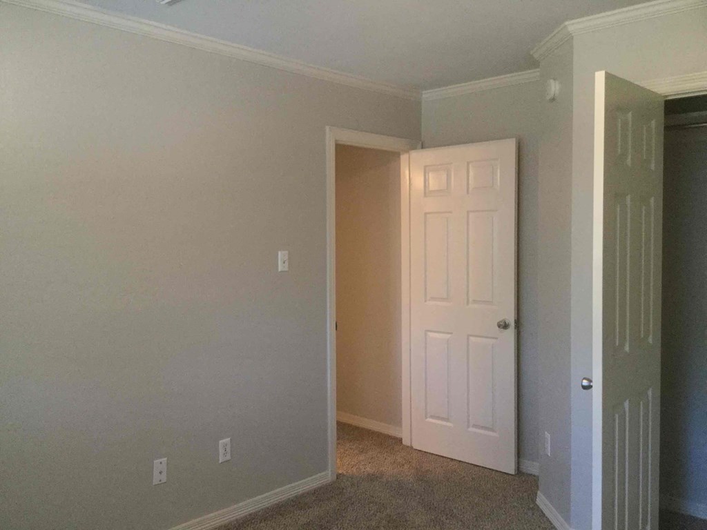 an empty room with a white door and a closet