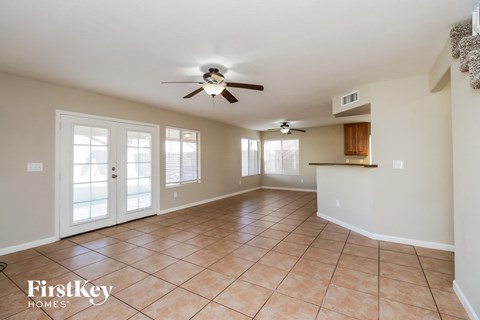 A spacious room with a ceiling fan and tiled floor.