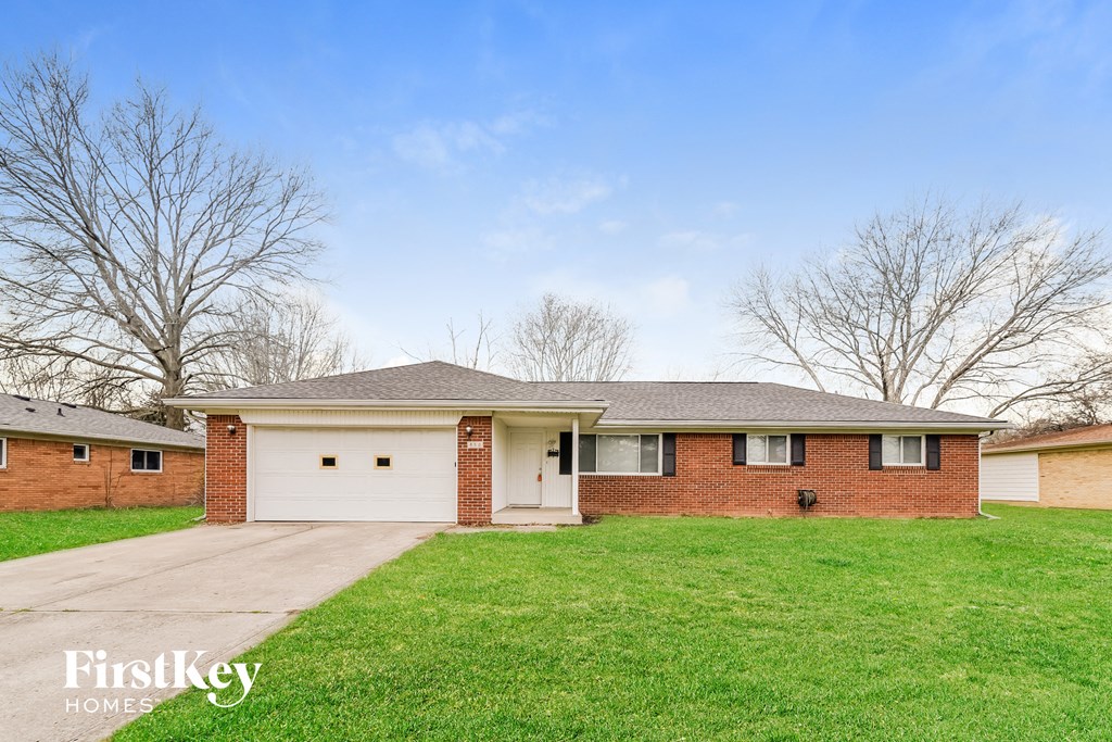 A brick house with a garage is for sale.