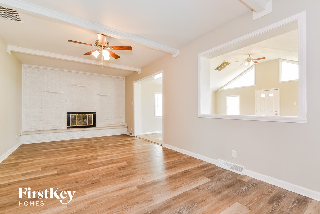 A room with a fireplace and a fan on the ceiling.