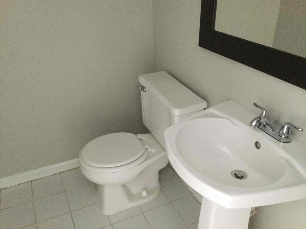a white bathroom with a toilet and a sink