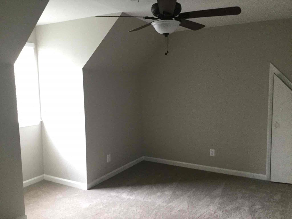 an empty room with a ceiling fan in it