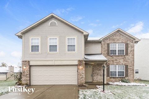 A house with a garage and a brick chimney is for sale.
