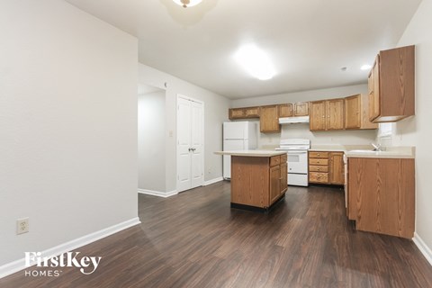 A kitchen with wooden cabinets and a white fridge.