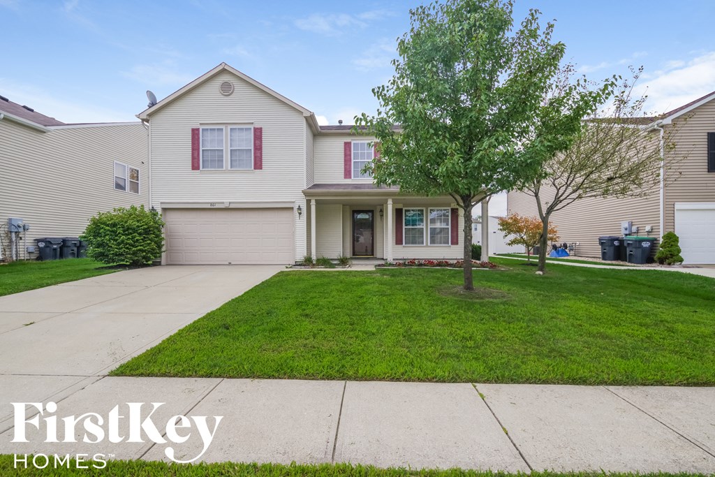 a white house with a lawn and a driveway