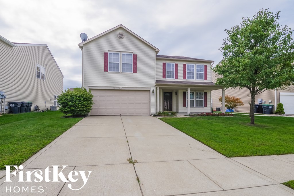 a white house with red shutters and a driveway