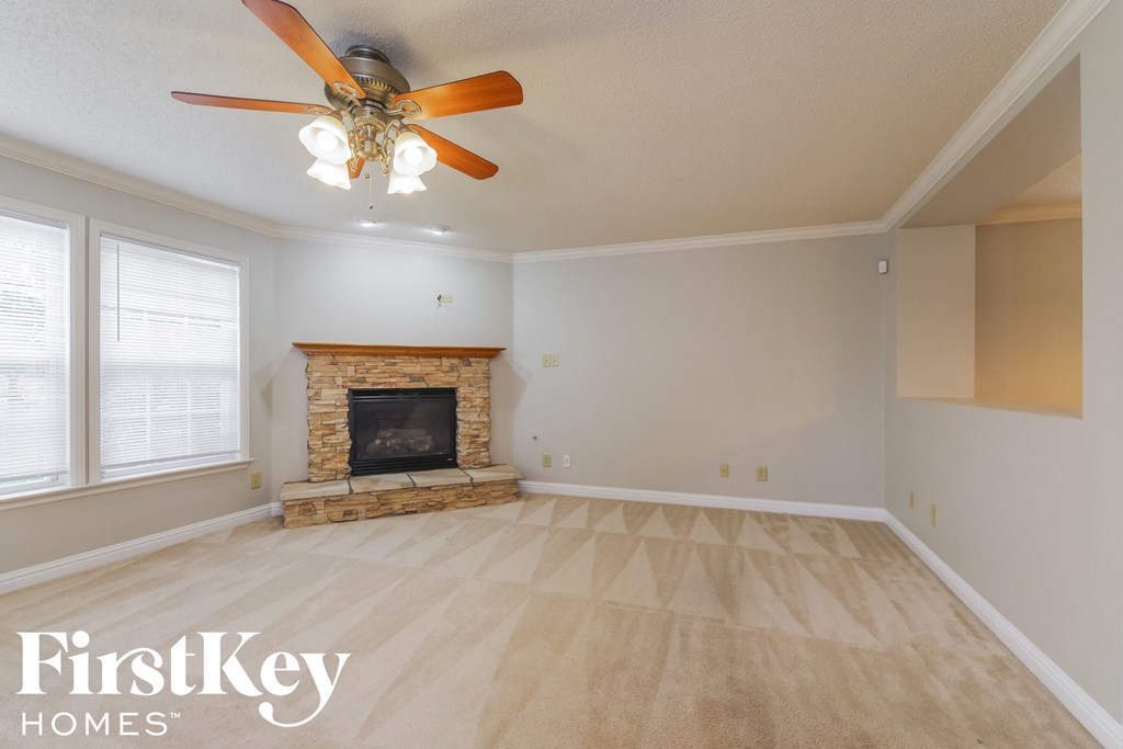 a living room with a fireplace and a ceiling fan