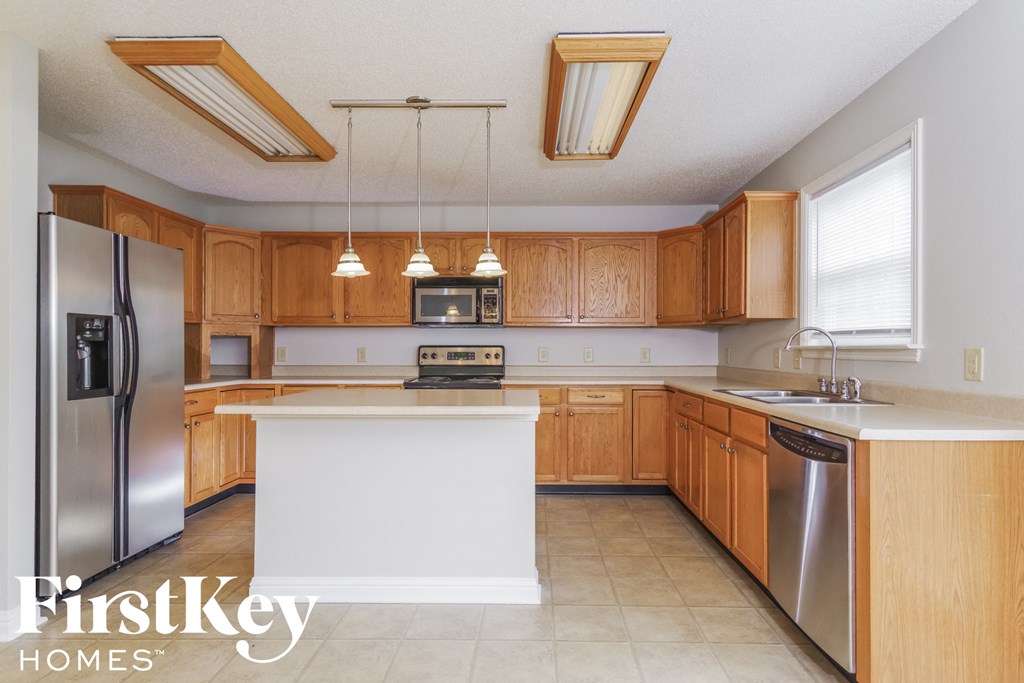 a kitchen with wooden cabinets and stainless steel appliances