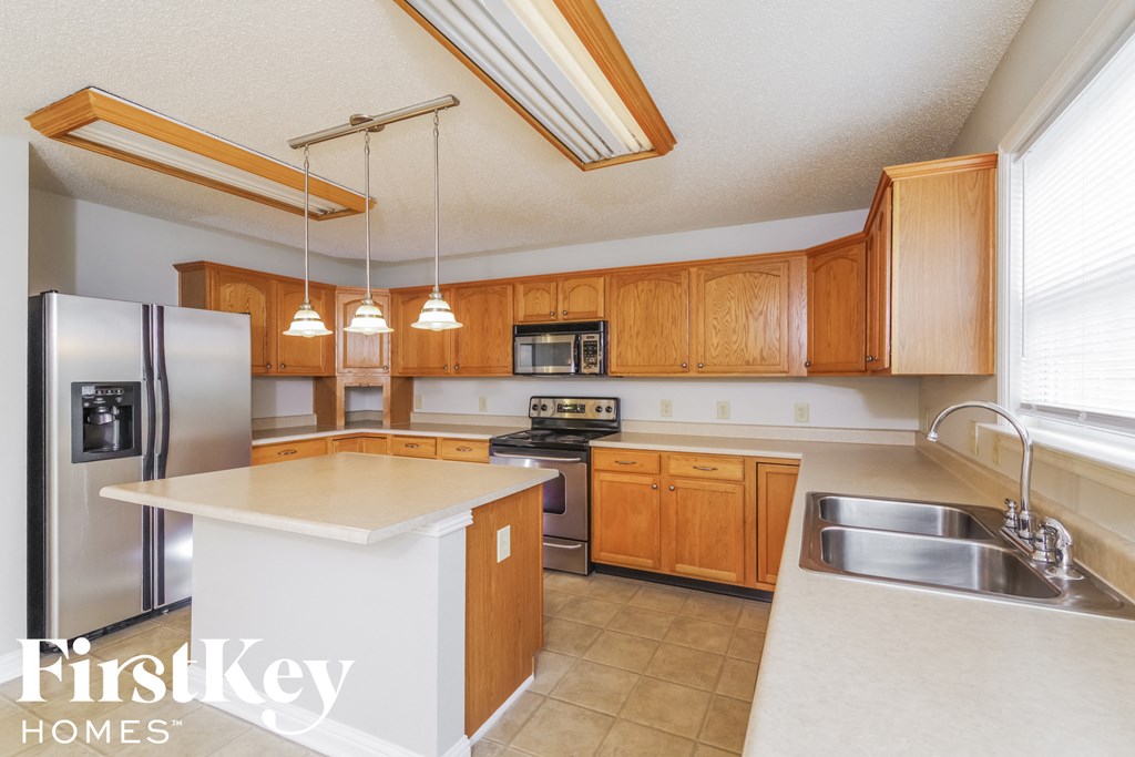 a kitchen with wooden cabinets and stainless steel appliances and a white counter top