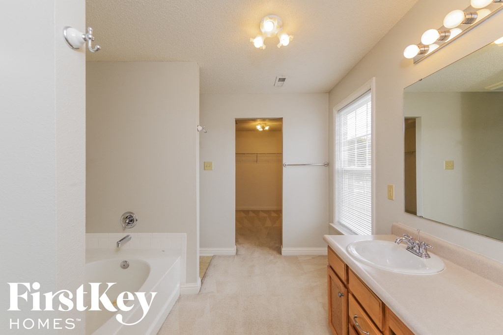 a bathroom with a tub and a sink and a mirror