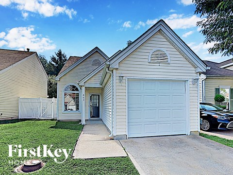 the front of a white house with a white garage door