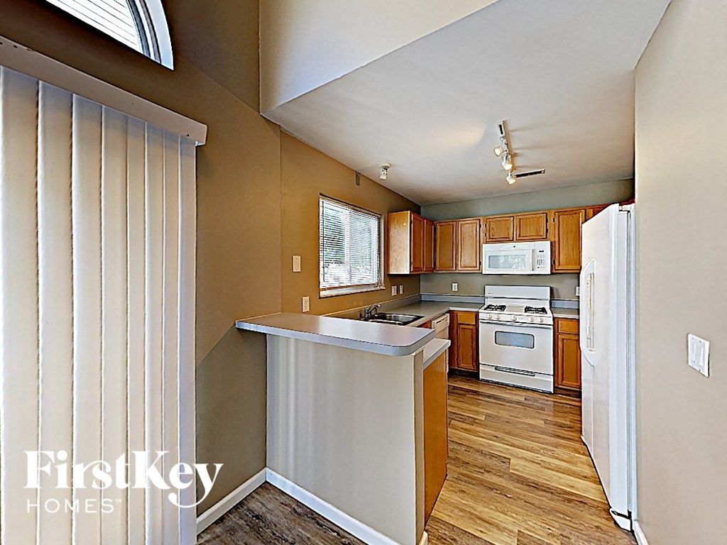 an open kitchen with wood floors and white appliances