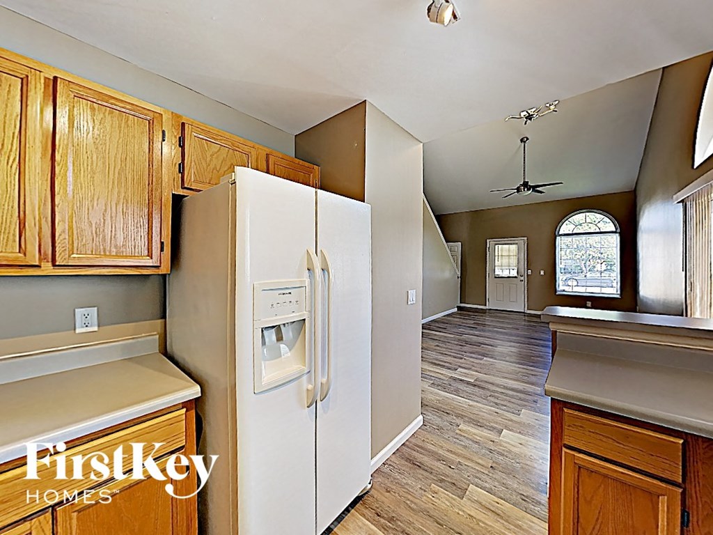 the kitchen is open to the living room and has a large refrigerator