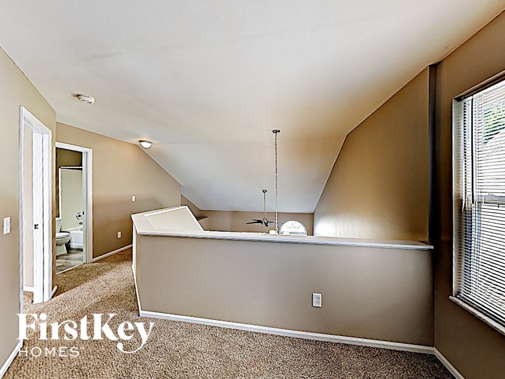 the upstairs kitchen and living room of a house with a large window
