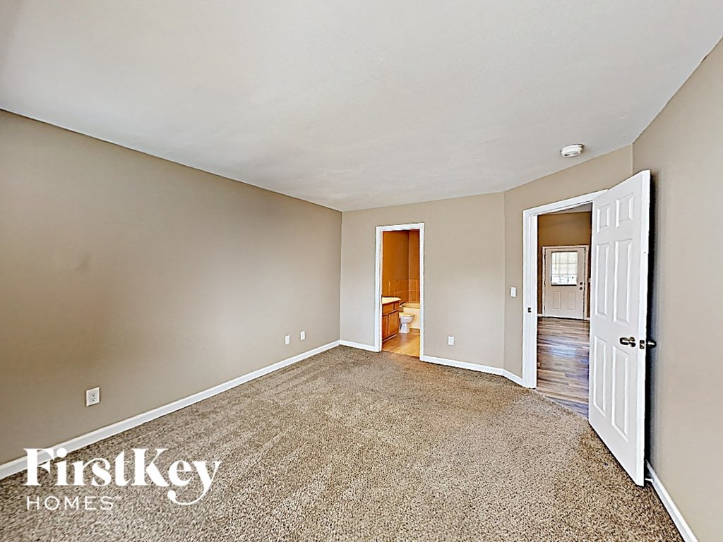 a bedroom with a white door and a carpeted floor