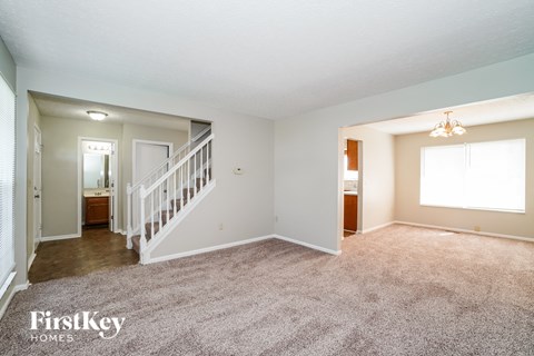 a living room with carpet and a staircase