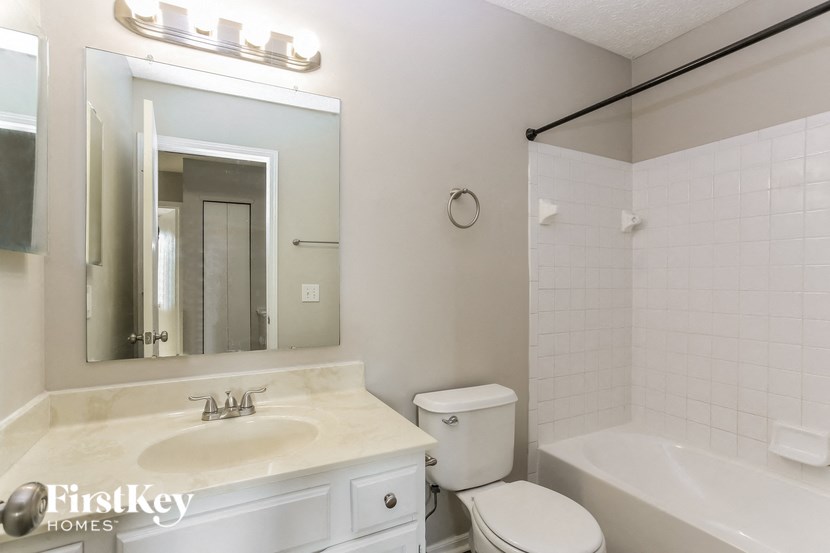 a bathroom with a sink toilet and a mirror