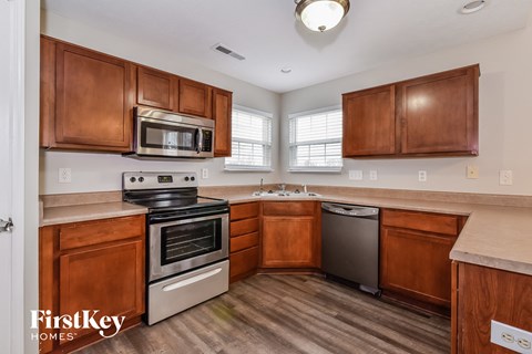 A kitchen with wooden cabinets and a stainless steel dishwasher.