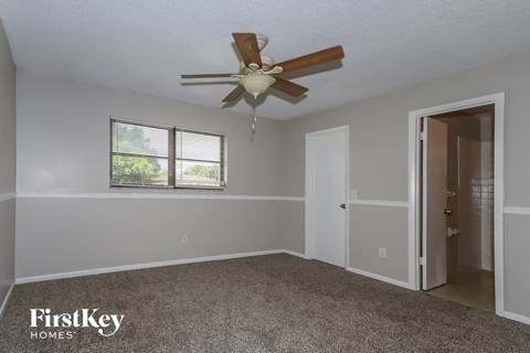 a bedroom with a ceiling fan and a door to a closet
