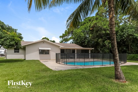 a house with a swimming pool and a fence