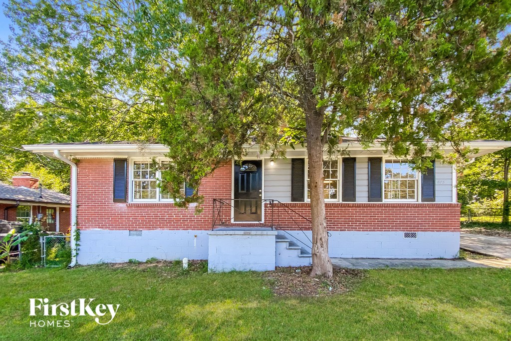 a brick house with a tree in front of it