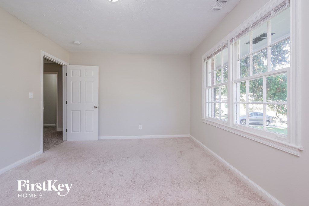 a bedroom with a carpeted floor and a large window