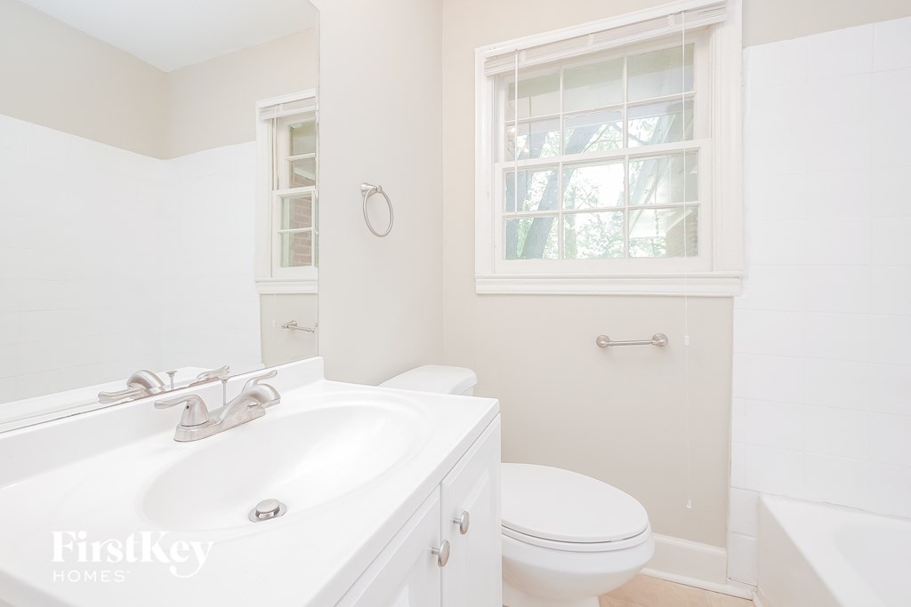 a white bathroom with a white toilet and a white sink