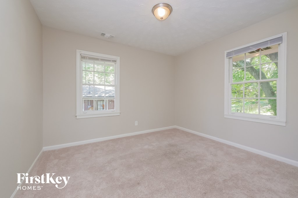 a bedroom with a carpeted floor and two windows