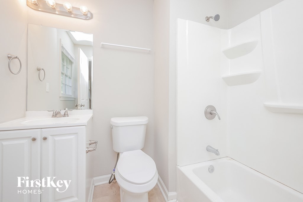 a white bathroom with a toilet and a tub and a sink