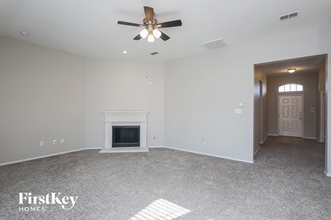 the living room with fireplace and ceiling fan