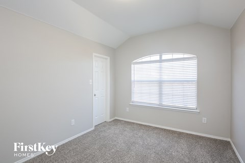 a bedroom with white walls and a window and a door