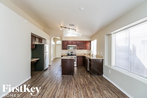 A kitchen with dark wood floors and a white ceiling.