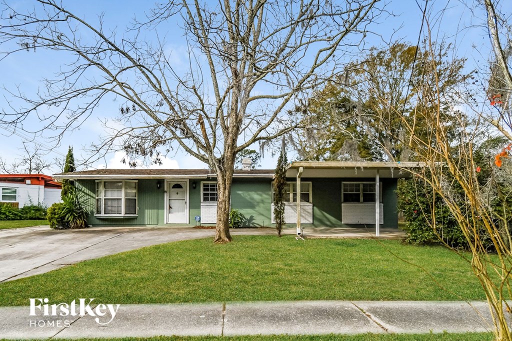 a green house with a lawn and a tree