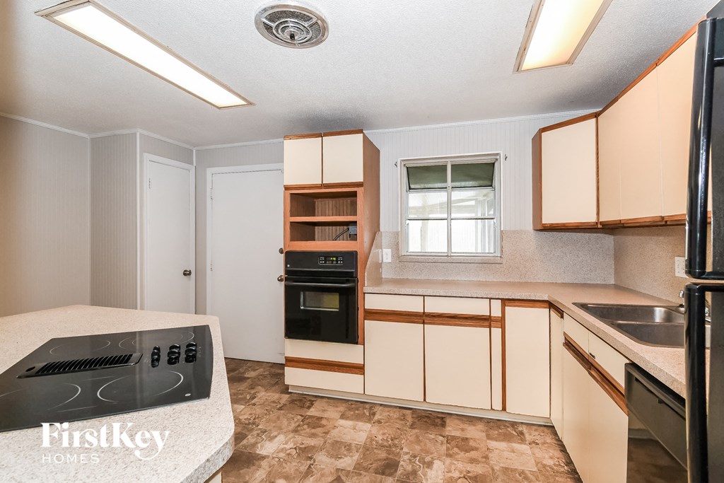 a kitchen with white cabinets and black appliances