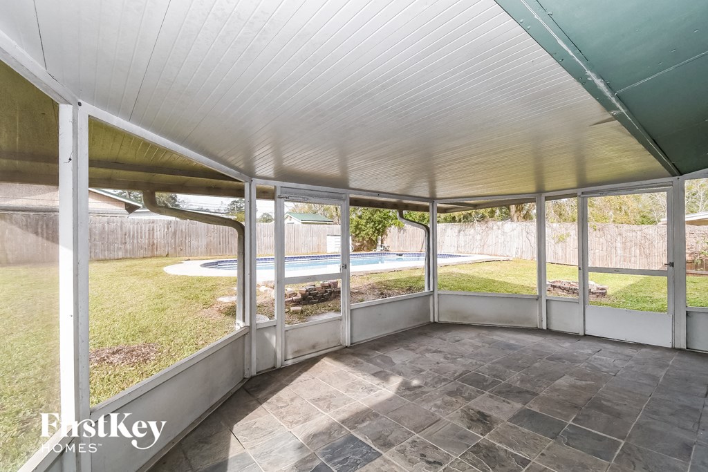 a screened in porch with a view of a yard and a pool