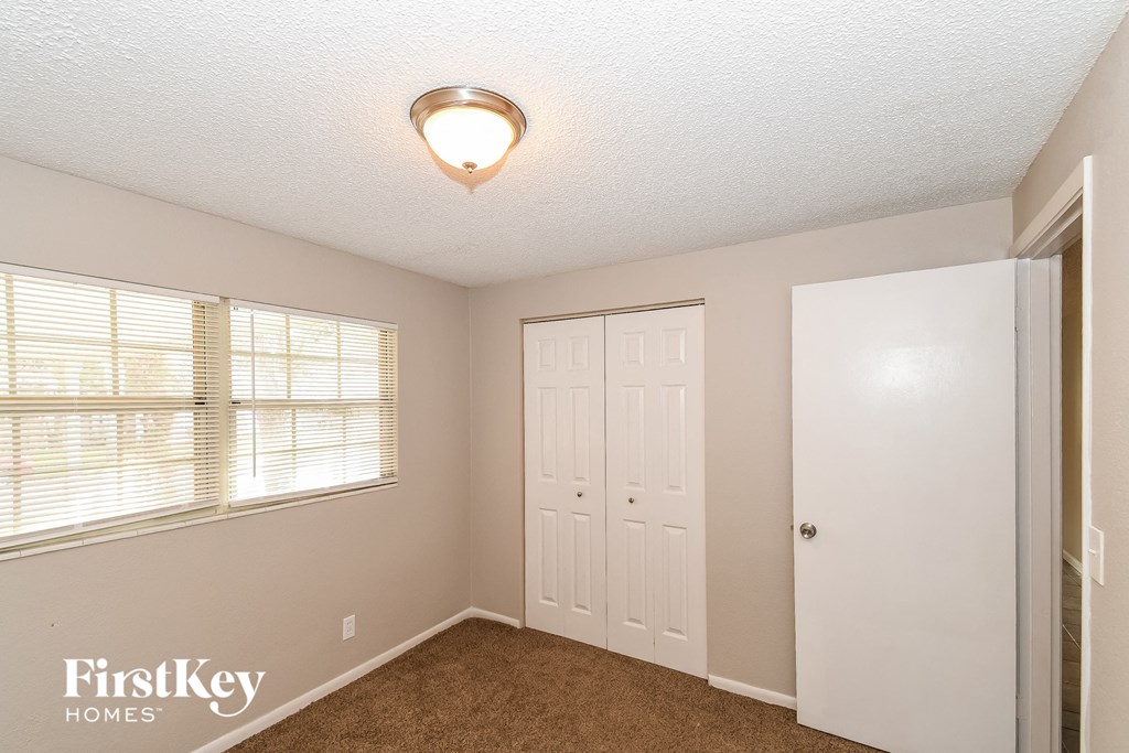 a bedroom with a closet and a door and a window