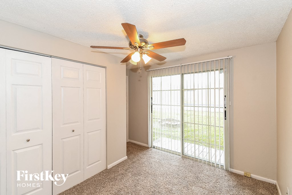 a living room with a ceiling fan and a large window
