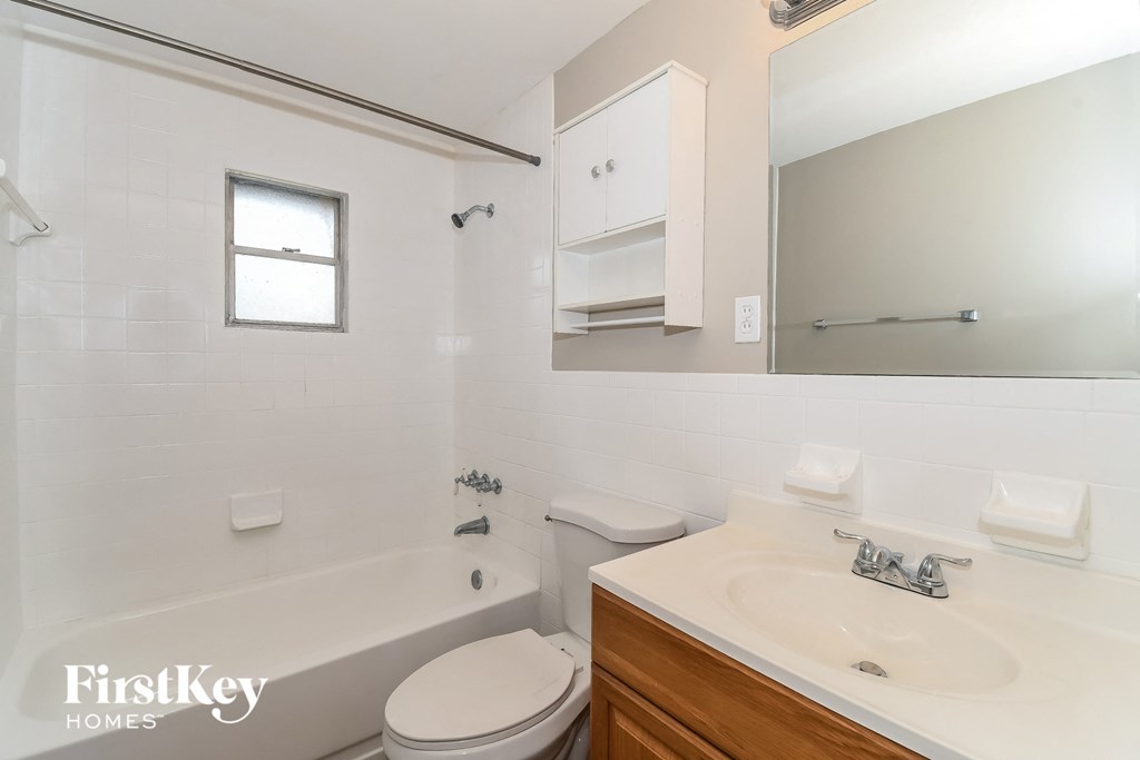 a bathroom with a sink toilet and tub and a mirror