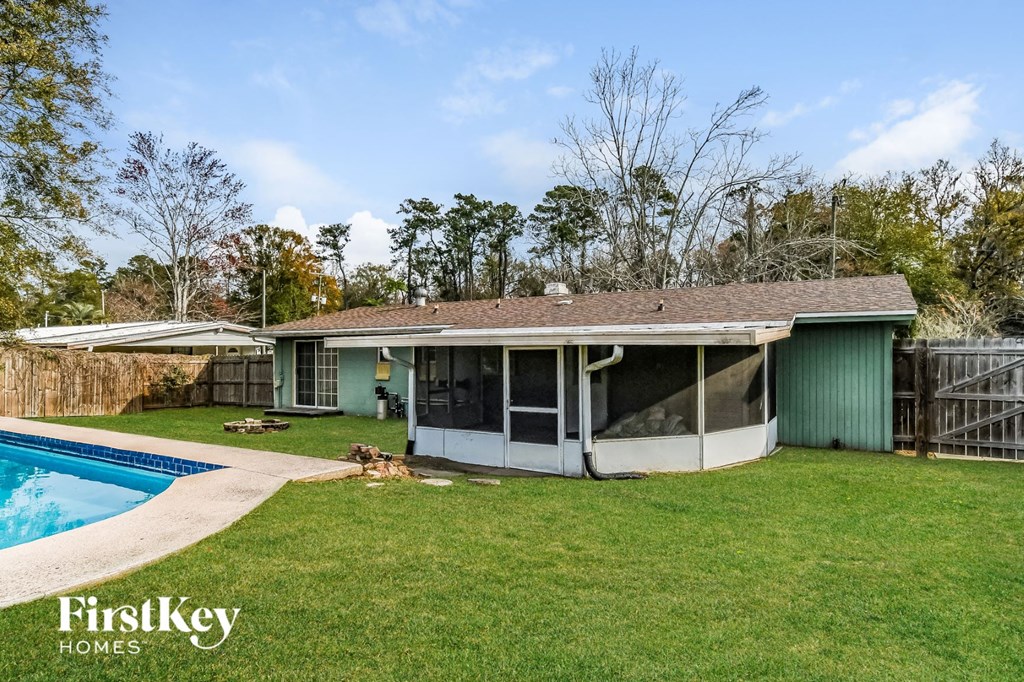 a backyard with a pool and a green house