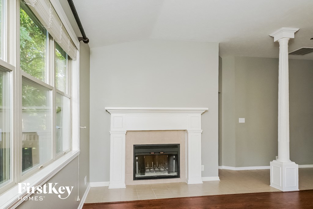 a living room with a fireplace and a large window