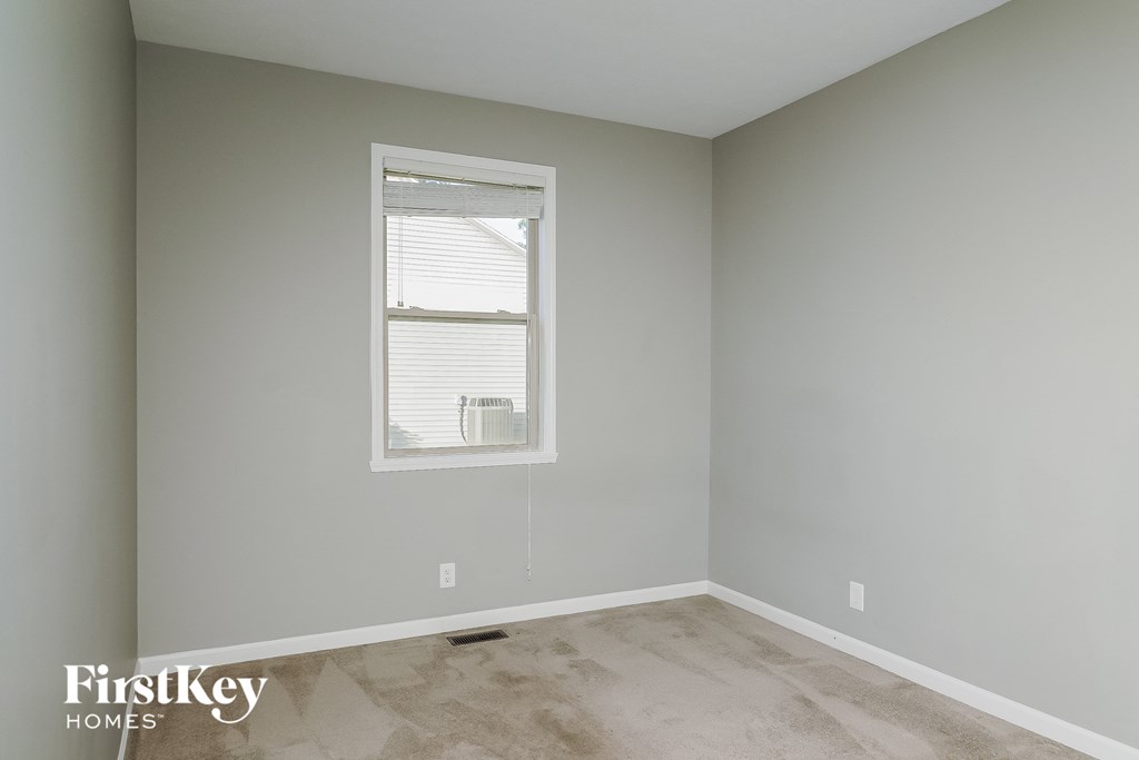a room with gray walls and a window with white window blinds