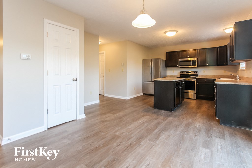 A kitchen with a refrigerator, oven, and microwave.