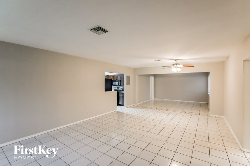 A spacious room with a tiled floor and a ceiling fan.